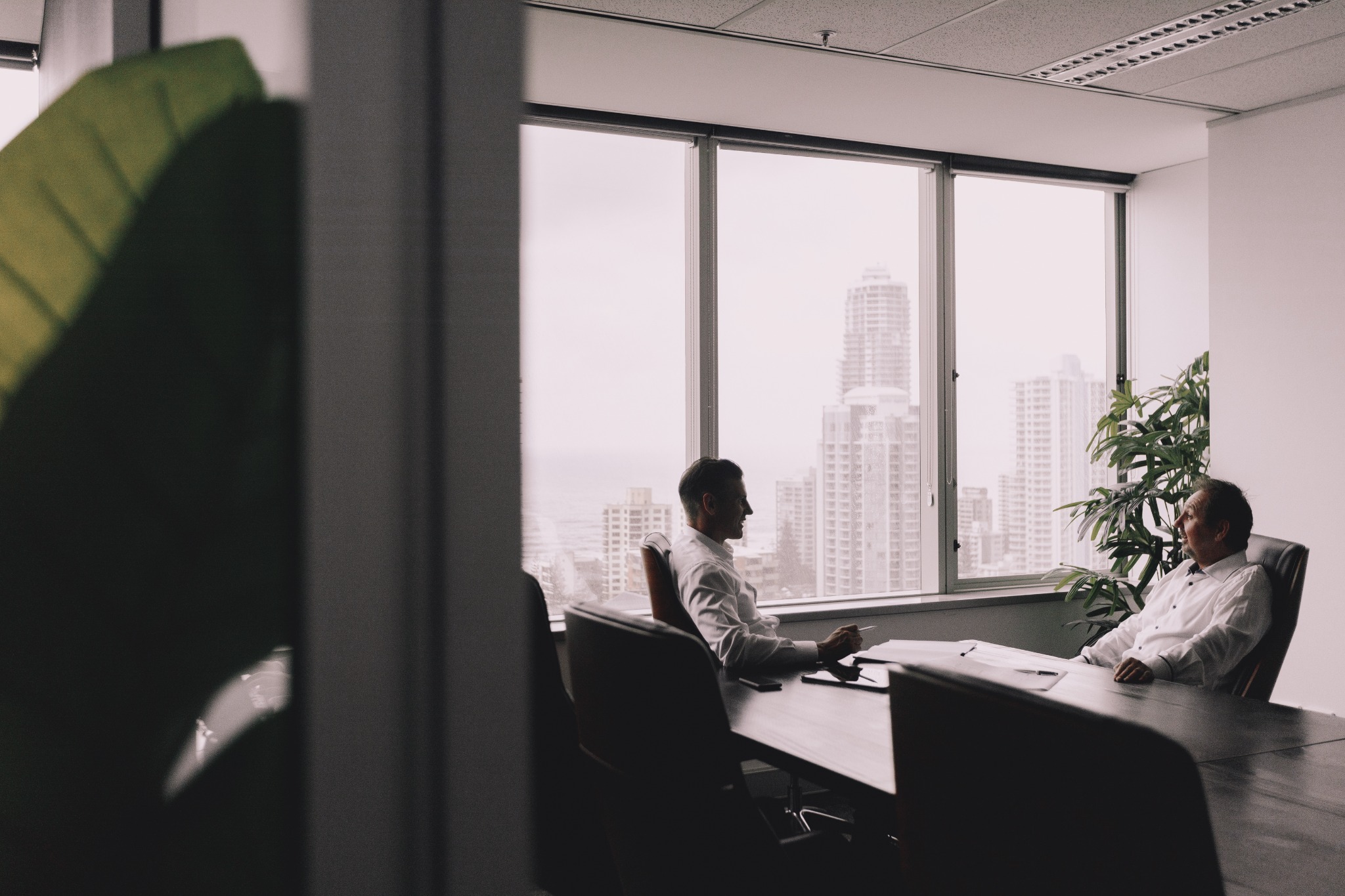 A meeting beside large windows overlooking the coastal skyline