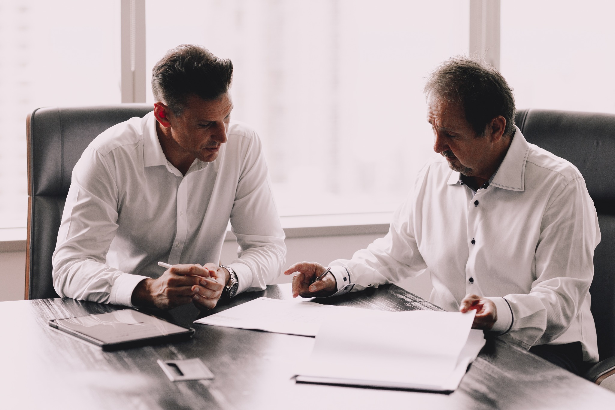 Two people discussing architectural plans at a meeting table