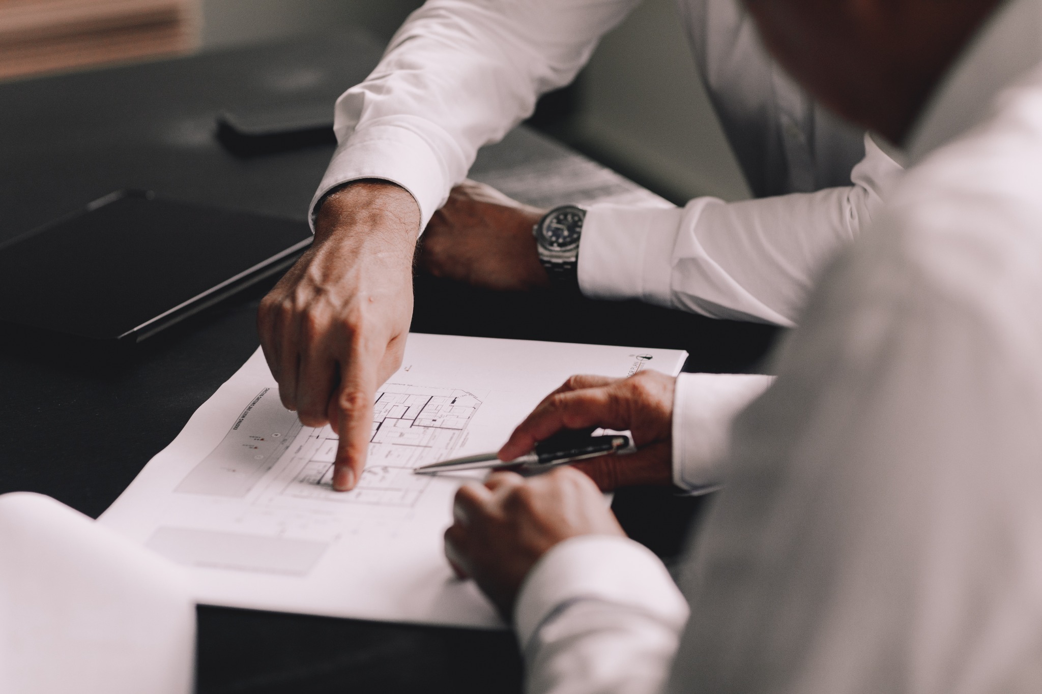 Hands reviewing a floor plan together